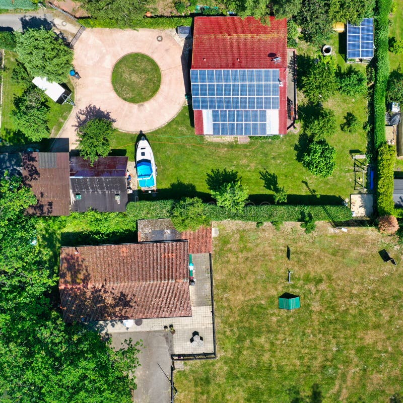 Gifhorn, Germany, July 3., 2019: Aerial view of a small cottage in the green with a solar system on the roof. Gifhorn, Germany, July 3., 2019: Aerial view of a small cottage in the green with a solar system on the roof