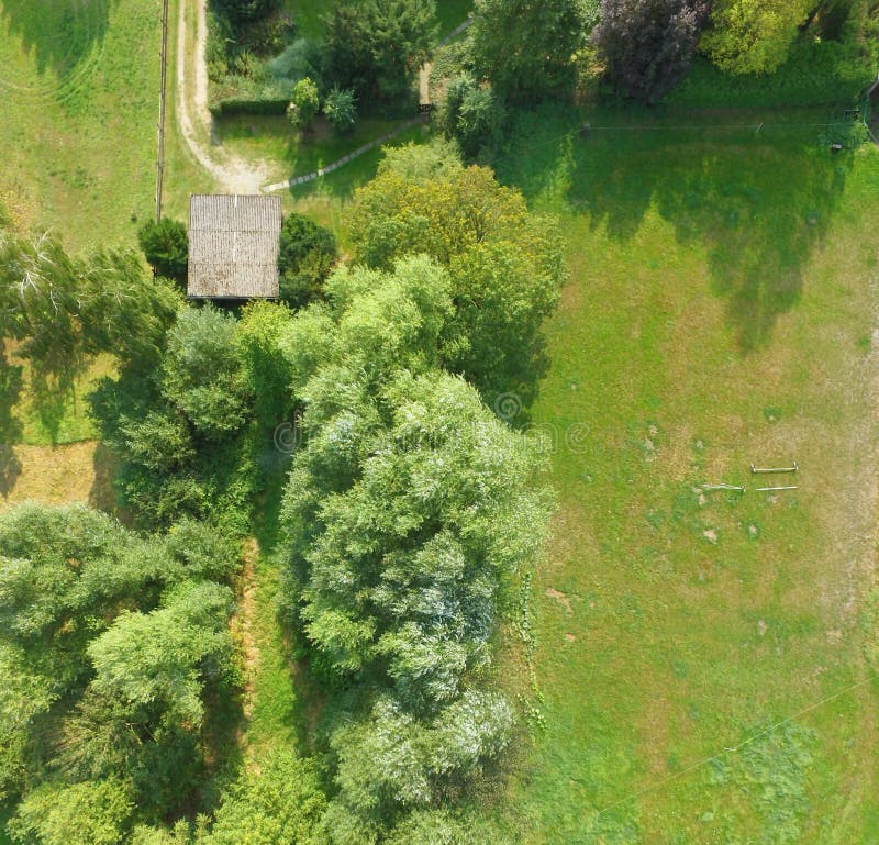 Vista aerea di un prato che confina un prato inglese, con una tettoia e parecchi cespugli ed alberi