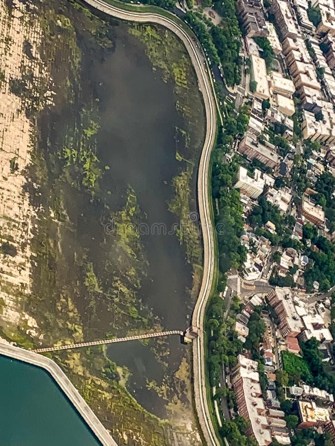 Vista aerea di un quartiere cittadino con una strada costiera lungo una palude fotografia stock Vista aerea di un quartiere cittadino con una strada costiera lungo una palude fotografia stock