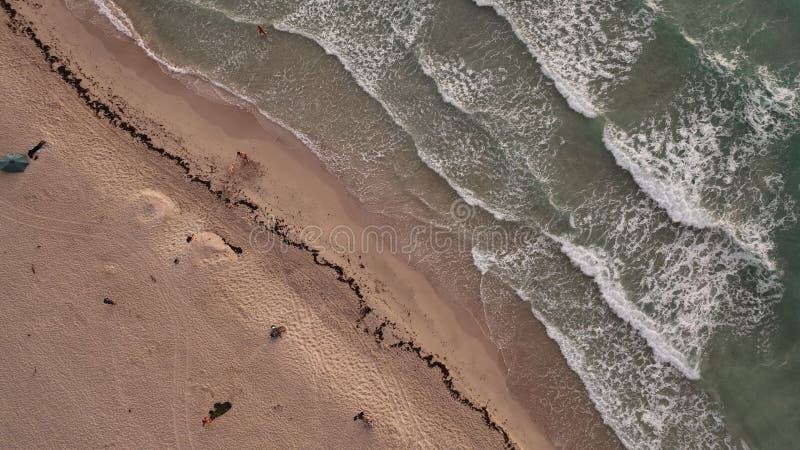 Vista aerea minimalista di una spiaggia sabbiosa con onde d'acqua splittanti. Una visione aerea minimalista di una spiaggia sabbiosa con onde d'acqua splittanti del mare