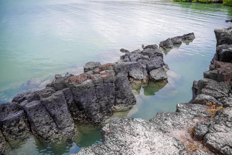 Vista al aire libre de las rocas volcánicas situadas en la laguna en el San Cristobal Island en la isla de las Islas Galápagos imagenes de archivo Vista al aire libre de las rocas volcánicas situadas en la laguna en el San Cristobal Island en la isla de las Islas Galápagos imagenes de archivo
