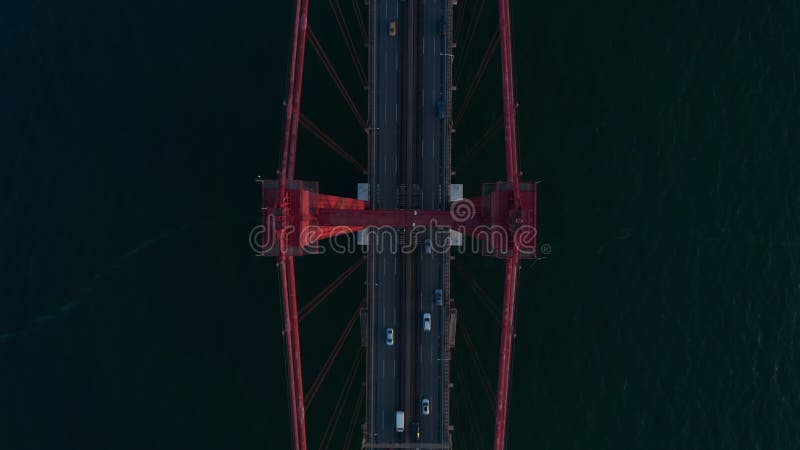 Vista aérea arriba abajo pájaros vista de tráfico de coches ocupados a través de ponte rojo 25 de abril puente a través del mar en almacen de video
