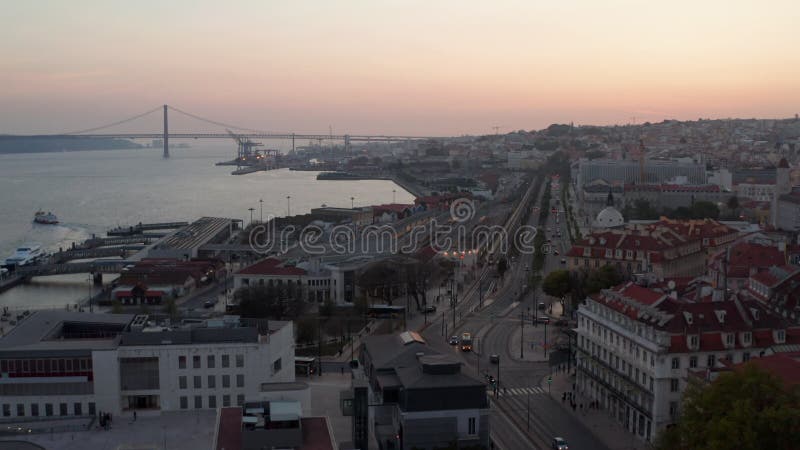 Vista aérea de autobús de múltiples carriles y tráfico de coches por la noche en la costa de lisboa portugal con ponte 25 de abril metrajes