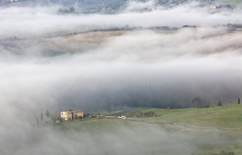 Vista aérea de casas da quinta da cume & de árvores de cipreste em Toscânia em uma manhã nevoenta da mola ~ fotos de stock Vista aérea de casas da quinta da cume & de árvores de cipreste em Toscânia em uma manhã nevoenta da mola ~ fotos de stock