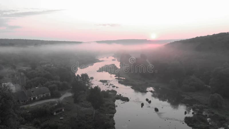 Vista aérea de drones sobre la salida del sol sobre el río helado. niebla sobre río tranquilo con rayos de sol. bosque por la maña