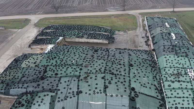 Vista aérea de grandes pilas de ensilado recubiertas de película de plástico y neumáticos usados almacen de metraje de vídeo