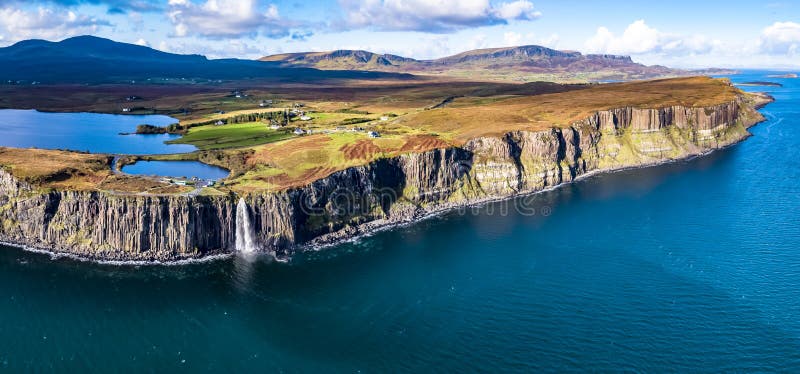 Vista aérea de la costa costa dramática en los acantilados por Staffin con la cascada famosa de la roca de la falda escocesa - is fotos de archivo libres de regalías Vista aérea de la costa costa dramática en los acantilados por Staffin con la cascada famosa de la roca de la falda escocesa - is fotos de archivo libres de regalías