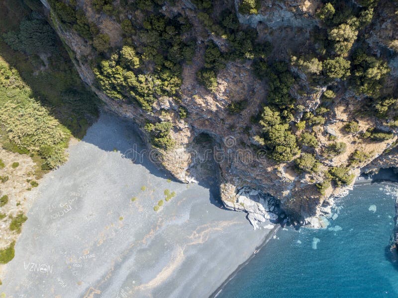 Vista aérea de um penhasco que negligencia o mar, praia preta, a municipalidade de Nonza, península de Cap Corse, Córsega foto de stock Vista aérea de um penhasco que negligencia o mar, praia preta, a municipalidade de Nonza, península de Cap Corse, Córsega foto de stock