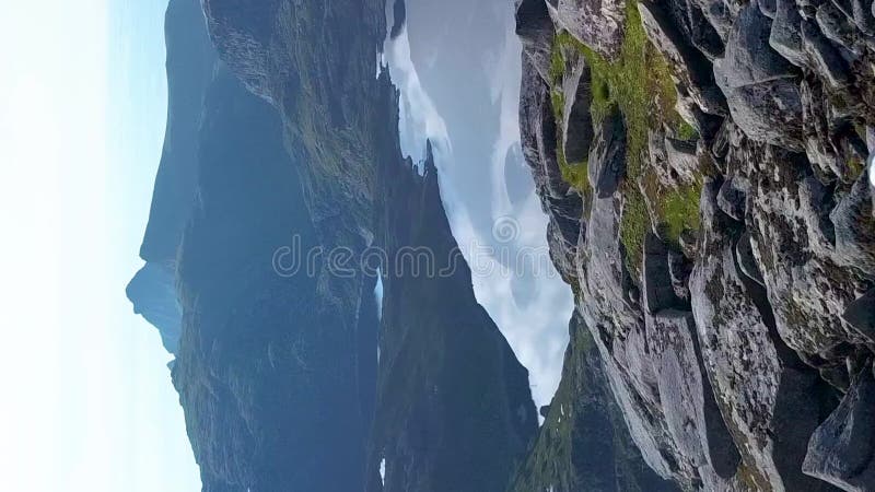 Vista aérea de uma garota com uma mochila viajando pelas montanhas das ilhas do lofoten