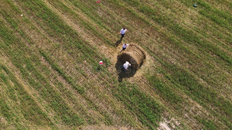 Vista aérea de una familia divertida corriendo alrededor de un pajar. metrajes