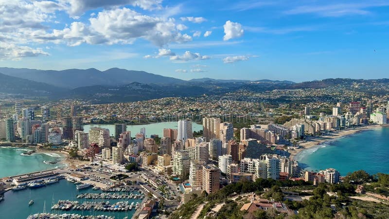 Vista aérea de una impresionante ciudad costera con majestuosas montañas y un precioso puerto deportivo almacen de metraje de vídeo
