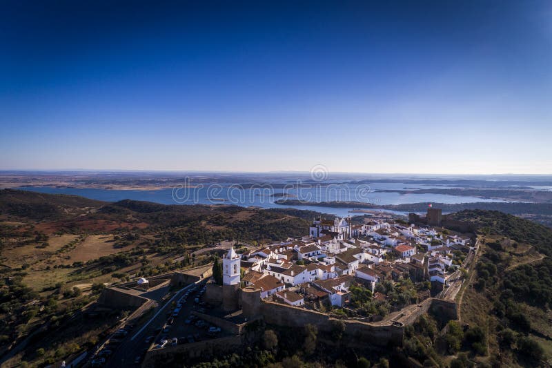 Vista aérea del pueblo histórico de Monsaraz en Alentejo con el depósito de la presa de Alqueva en el fondo foto de archivo Vista aérea del pueblo histórico de Monsaraz en Alentejo con el depósito de la presa de Alqueva en el fondo foto de archivo