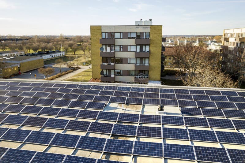 Vista aérea del sistema voltáico de los paneles de la foto solar brillante azul en el tejado comercial produciendo la energía lim fotografía de archivo Vista aérea del sistema voltáico de los paneles de la foto solar brillante azul en el tejado comercial produciendo la energía lim fotografía de archivo