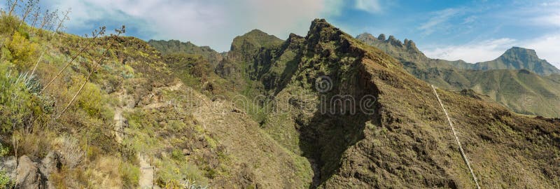 Vista aérea do desfiladeiro famoso do inferno em Adeje Dia ensolarado Céu azul e nuvens acima das montanhas Estrada de seguimento foto de stock royalty free Vista aérea do desfiladeiro famoso do inferno em Adeje Dia ensolarado Céu azul e nuvens acima das montanhas Estrada de seguimento foto de stock royalty free