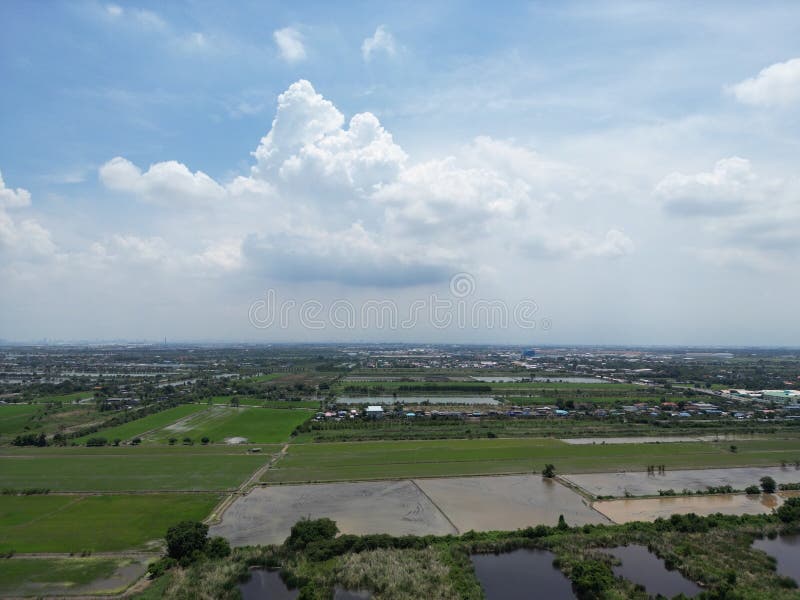 Vista aérea dos campos verdes e da cidade sob céu nublado. foto de stock royalty free
