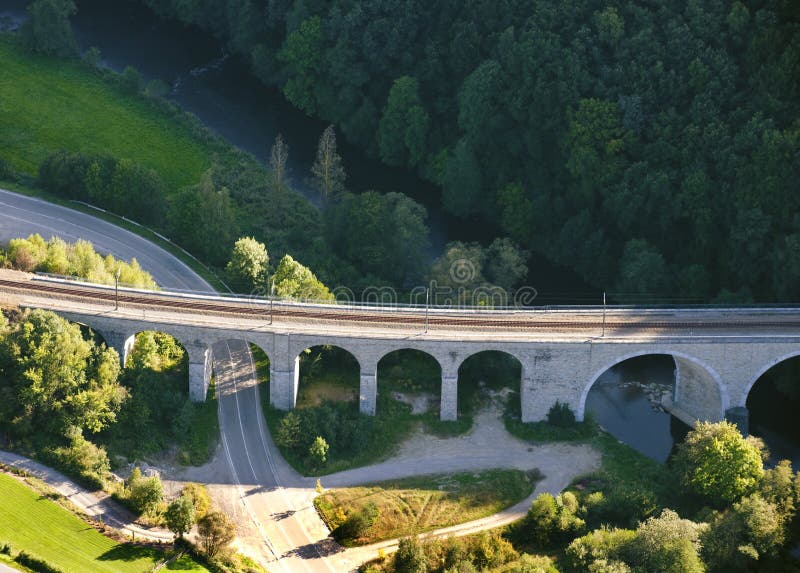 Vista aérea: Ponte velha da estrada de ferro que cruza uma estrada foto de stock Vista aérea: Ponte velha da estrada de ferro que cruza uma estrada foto de stock