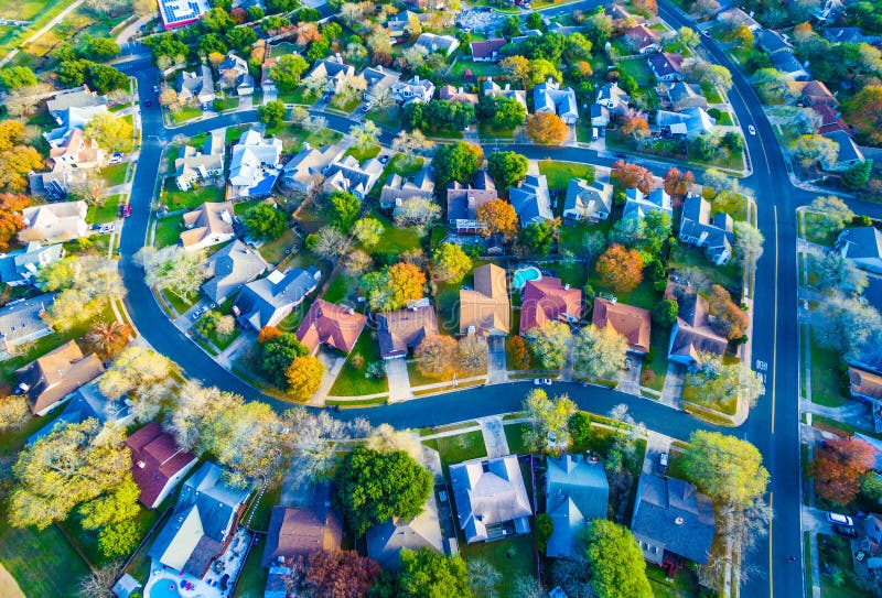A vista aérea sobre a comunidade moderna da casa do subúrbio com cores da queda curvou Streetes
