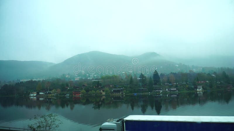 Vista bonita das montanhas na névoa e no rio da janela de passar o trem no outono