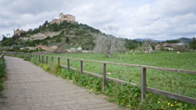 Vista borrosa de un pintoresco camino que conduce a un histórico castillo en lo alto de una colina en arta mallorca con exuberante imagenes de archivo
