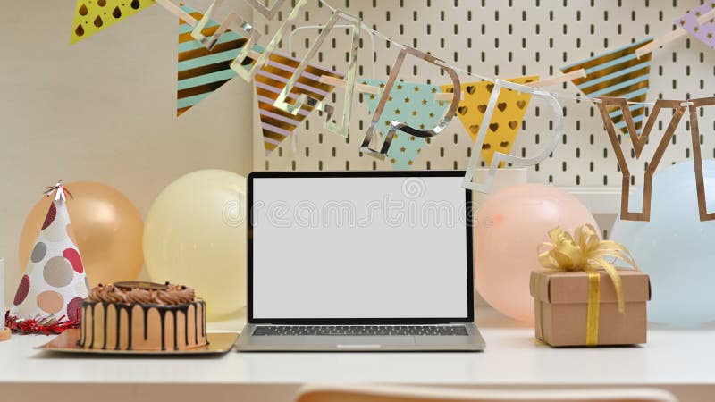 Vista completa del tavolo con le decorazioni per il compleanno, torta per notebook e presente fotografia stock libera da diritti