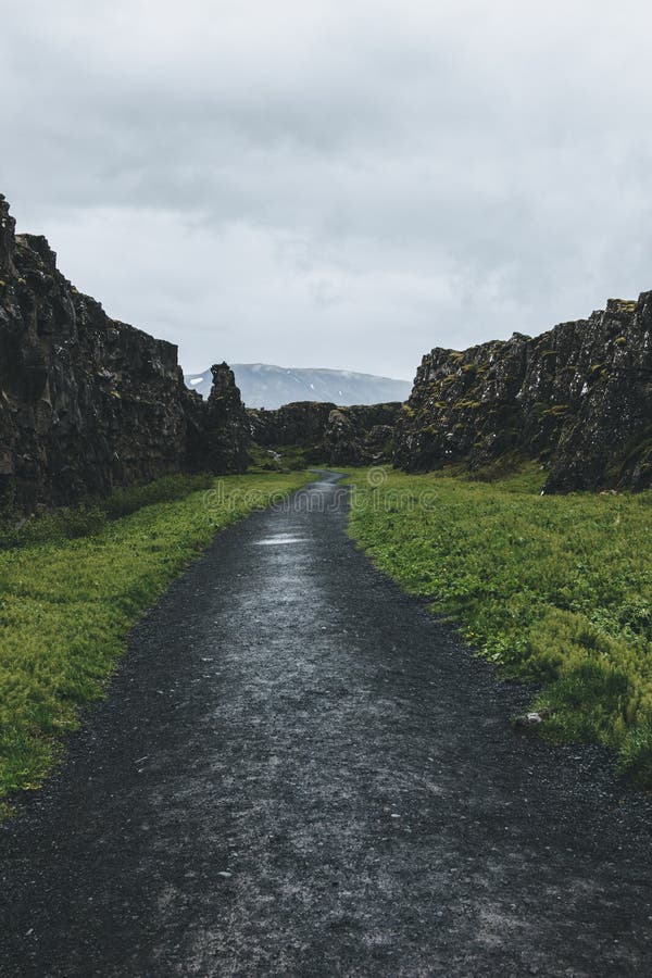 vista cênico do trajeto nas montanhas sob o céu nebuloso no parque nacional de Thingvellir imagens de stock vista cênico do trajeto nas montanhas sob o céu nebuloso no parque nacional de Thingvellir imagens de stock