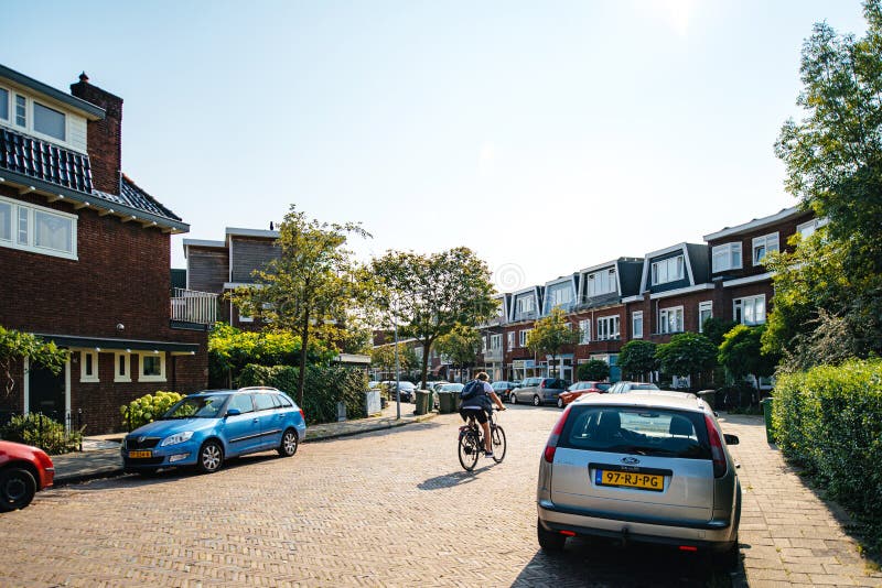 Vista da retaguarda dos jovens ciclistas que entram no Van der Meerstraat imagens de stock Vista da retaguarda dos jovens ciclistas que entram no Van der Meerstraat imagens de stock