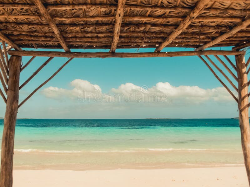 Vista da una cabana sulla spiaggia caraibica, oceano blu e cielo nuvoloso Una giornata estiva perfetta immagini stock libere da diritti Vista da una cabana sulla spiaggia caraibica, oceano blu e cielo nuvoloso Una giornata estiva perfetta immagini stock libere da diritti