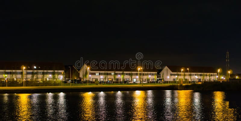 Vista da água em casas e da estrada da condução na noite, opinião holandesa da rua de landschapsbaan, o Meern, Utrecht foto de stock Vista da água em casas e da estrada da condução na noite, opinião holandesa da rua de landschapsbaan, o Meern, Utrecht foto de stock
