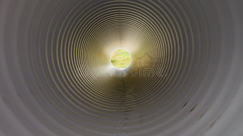 Vista dall'interno del tubo dell'acqua di plastica. luce alla fine del tunnel