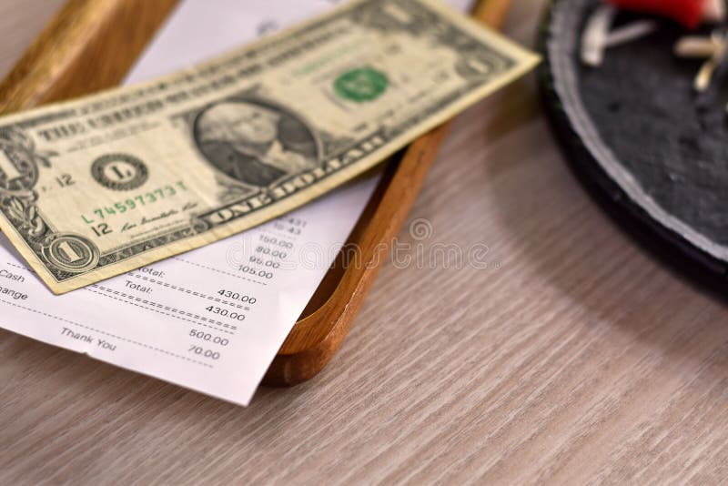 Vista de clausura consejo de dinero para servicio en el restaurante dinero en dólares en placa de madera. imagen de archivo libre de regalías Vista de clausura consejo de dinero para servicio en el restaurante dinero en dólares en placa de madera. imagen de archivo libre de regalías