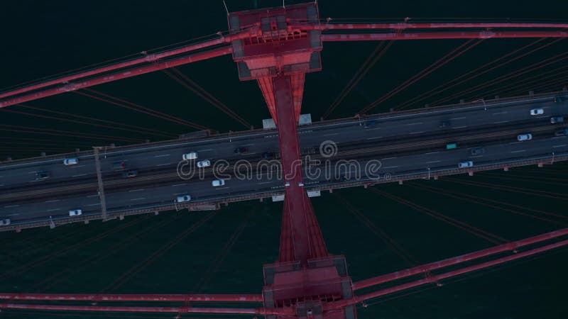 Vista de los pájaros altos sobre el fondo de la vista de los vehículos que cruzan un ponte rojo 25 de abril bridge frente al mar c almacen de metraje de vídeo