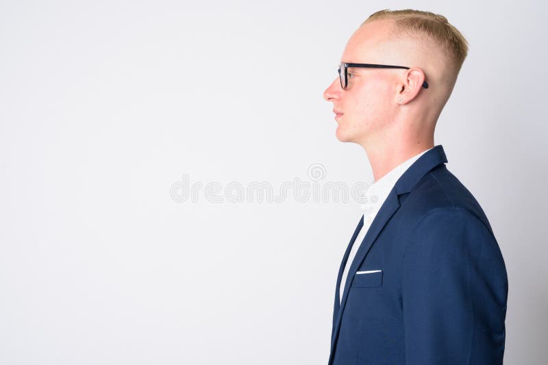 Vista de perfil de um homem bonito com cabelo loiro olhando para a câmera  ao ar livre