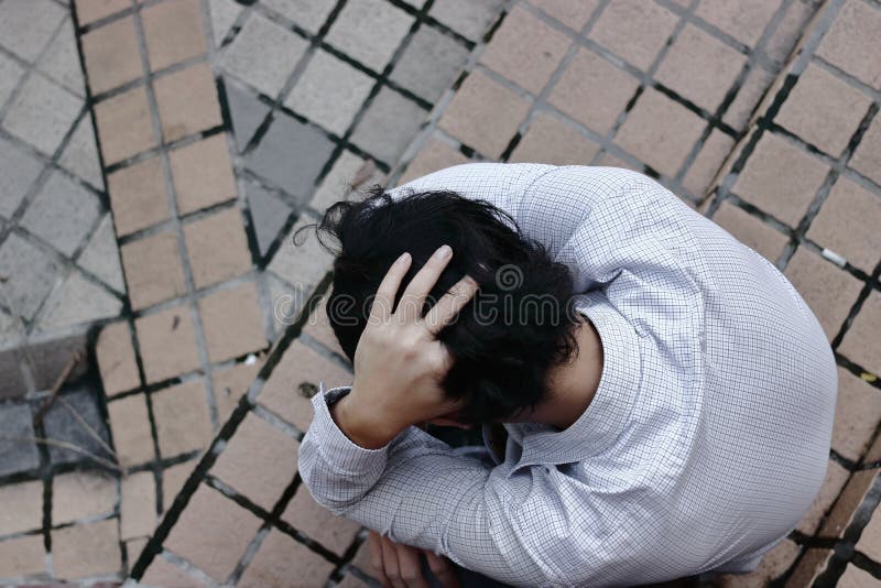 Vista de pájaro del hombre de negocios asiático subrayado deprimido que sufre de problema foto de archivo Vista de pájaro del hombre de negocios asiático subrayado deprimido que sufre de problema foto de archivo