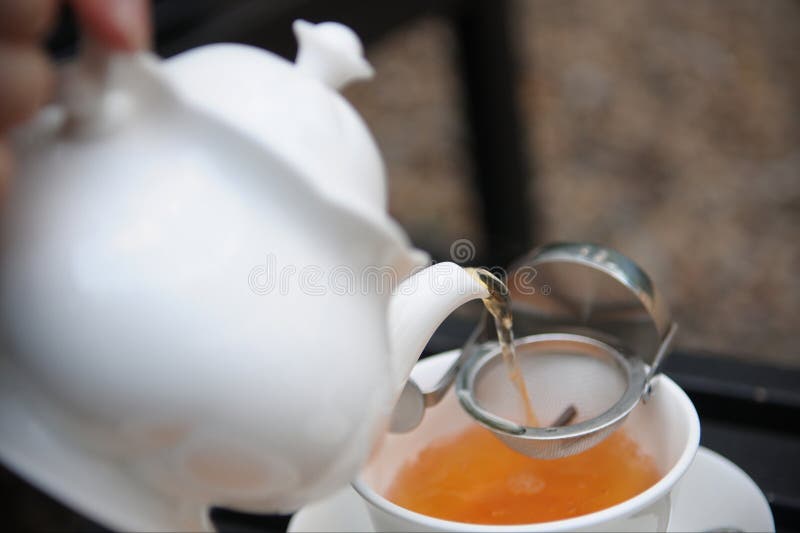 Vista de una tetera con té vertido en una taza. imagen de archivo libre de regalías