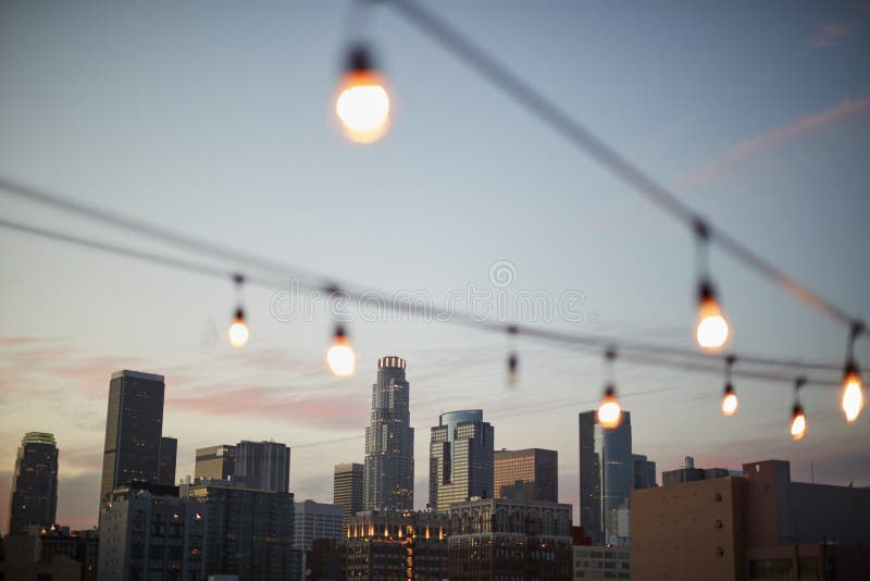 View Of Los Angeles Skyline At Sunset With String Of Lights In Foreground. View Of Los Angeles Skyline At Sunset With String Of Lights In Foreground