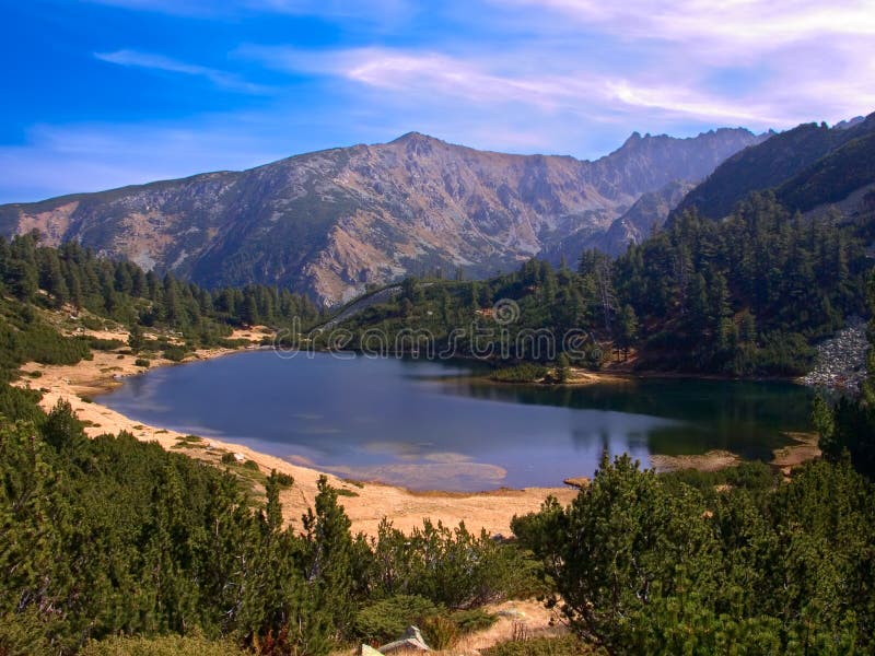 Vista del lago glacial con algunas montañas en el fondo en el parque nacional Pirin fotos de archivo Vista del lago glacial con algunas montañas en el fondo en el parque nacional Pirin fotos de archivo