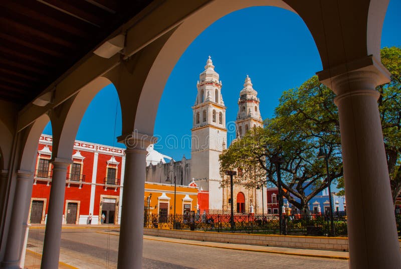 Vista del parque principal a través del arco del edificio de biblioteca en Campeche, México En el fondo es la catedral del la con imagen de archivo libre de regalías