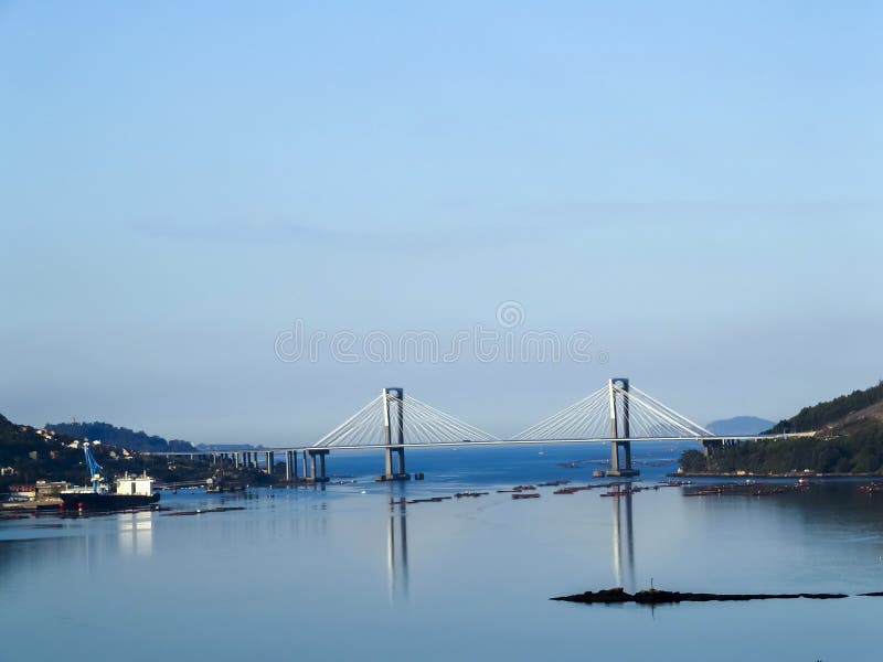 Beautiful view of the Rande bridge in the Vigo estuary. The sea is completely calm, reflecting the bridge with total clarity. Beautiful view of the Rande bridge in the Vigo estuary. The sea is completely calm, reflecting the bridge with total clarity.