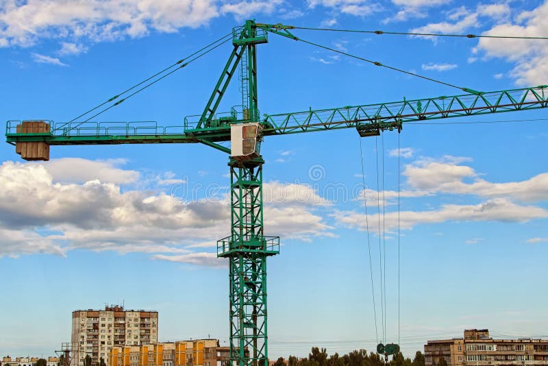 Vista del primo piano della gru contro cielo blu con le belle nuvole bianche Gru a torre verde che costruisce il nuovo edificio r fotografia stock libera da diritti Vista del primo piano della gru contro cielo blu con le belle nuvole bianche Gru a torre verde che costruisce il nuovo edificio r fotografia stock libera da diritti