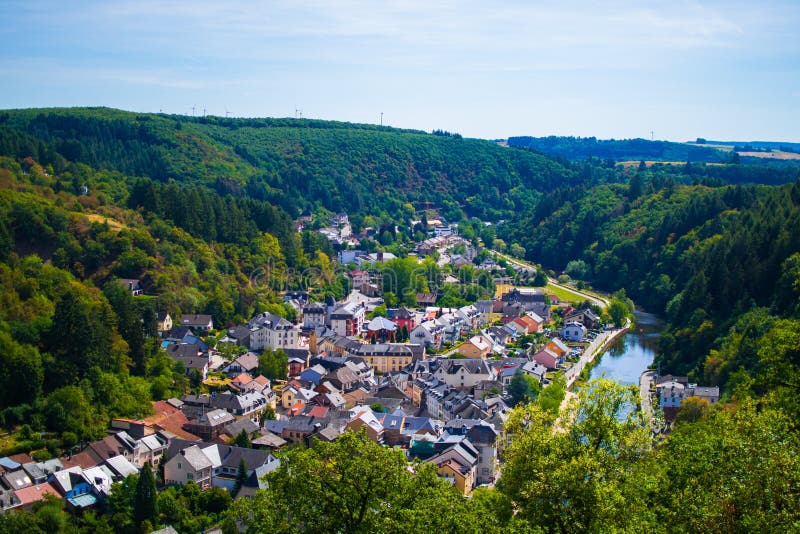 Vista del villaggio e della valle di Vianden, con le montagne e la foresta ed il nostro incrocio di fiume, a Lussemburgo, Europa fotografia stock Vista del villaggio e della valle di Vianden, con le montagne e la foresta ed il nostro incrocio di fiume, a Lussemburgo, Europa fotografia stock