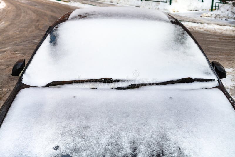 Vista delantera sobre el coche cubierto por la nieve en invierno fotos de archivo libres de regalías Vista delantera sobre el coche cubierto por la nieve en invierno fotos de archivo libres de regalías
