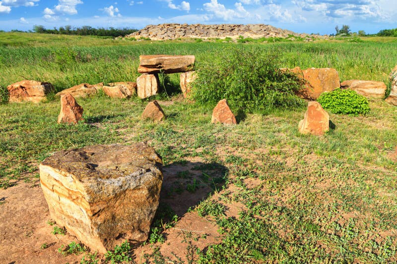 View of the ancient stone megaliths, a place of religious sanctuary, against the backdrop of an ancient mound of sandstone boulders, in the archeological preserve Kamyana Mohyla, Ukraine. View of the ancient stone megaliths, a place of religious sanctuary, against the backdrop of an ancient mound of sandstone boulders, in the archeological preserve Kamyana Mohyla, Ukraine