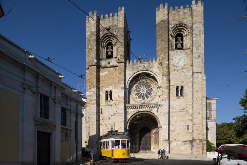 Vista della cattedrale di lisbona se de lisboa con un iconico tram giallo che passa davanti a sé nella città di lisbona fotografie stock libere da diritti