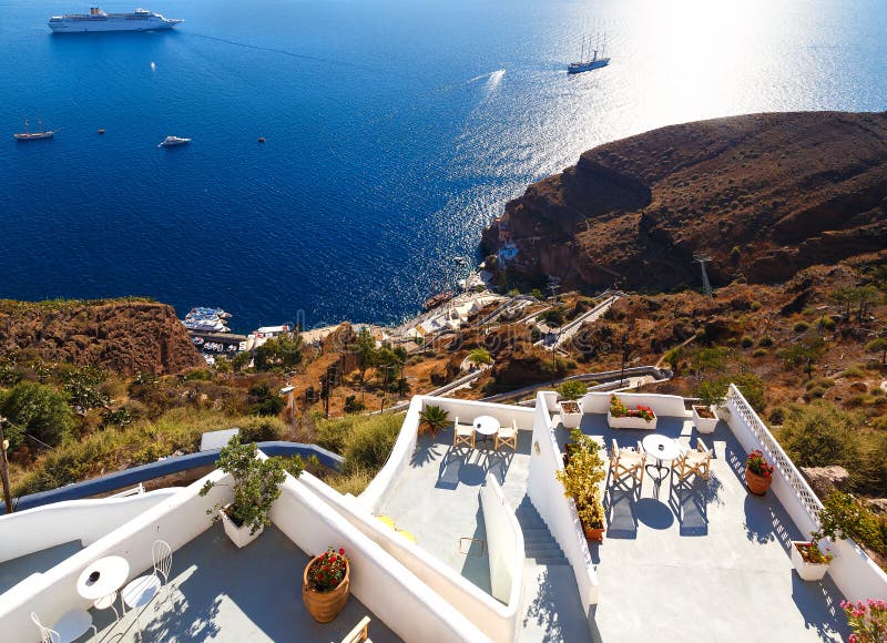 Vista della città di Fira - isola di Santorini, Creta, Grecia Balconi concreti bianchi dell'hotel che conduce giù alla bella baia fotografia stock libera da diritti Vista della città di Fira - isola di Santorini, Creta, Grecia Balconi concreti bianchi dell'hotel che conduce giù alla bella baia fotografia stock libera da diritti