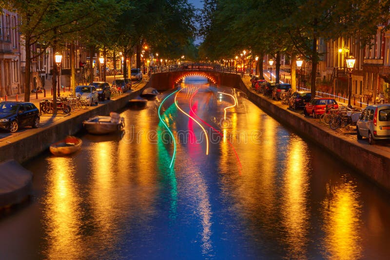 Vista della città di notte del canale di Amsterdam e della pista luminosa dalla b fotografie stock Vista della città di notte del canale di Amsterdam e della pista luminosa dalla b fotografie stock