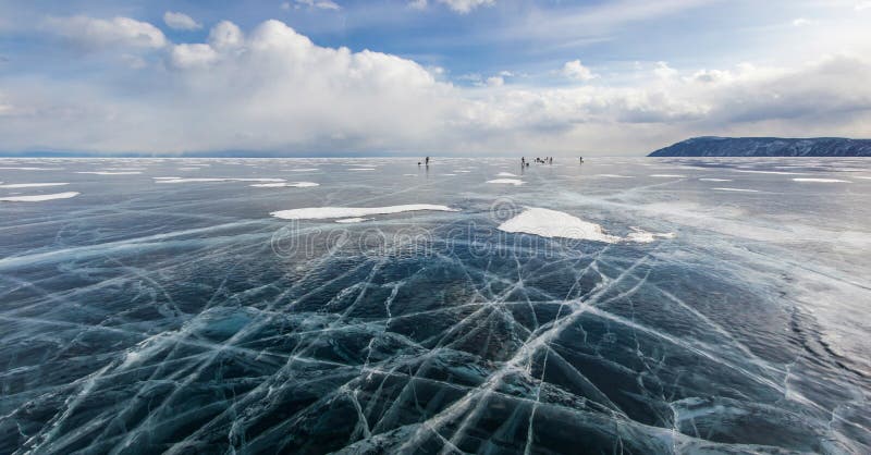vista della superficie dell'acqua ghiacciata sotto il cielo nuvoloso durante il giorno ed il gruppo di viandanti su fondo, Russia fotografie stock vista della superficie dell'acqua ghiacciata sotto il cielo nuvoloso durante il giorno ed il gruppo di viandanti su fondo, Russia fotografie stock
