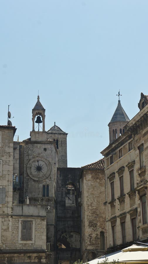 Vista della via con l'orologio della città e delle case di pietra in vecchia città, bella architettura, giorno soleggiato, spacca fotografia stock libera da diritti Vista della via con l'orologio della città e delle case di pietra in vecchia città, bella architettura, giorno soleggiato, spacca fotografia stock libera da diritti