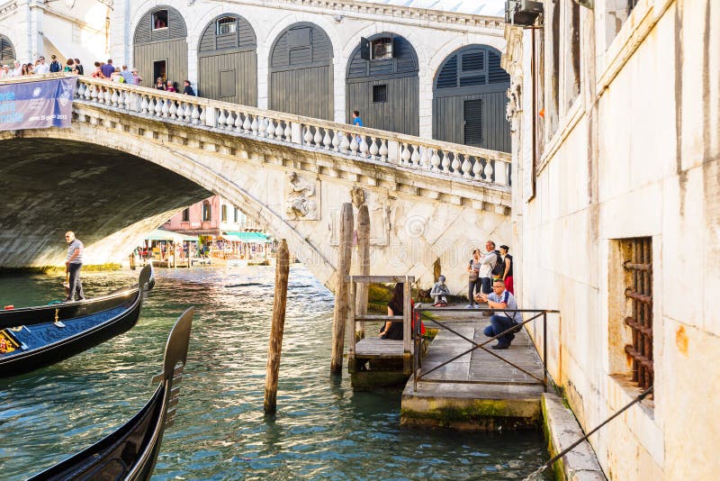 Vista delle gondole sul canal grande e su Ponte di Rialto, molti turisti su un ponte immagine stock Vista delle gondole sul canal grande e su Ponte di Rialto, molti turisti su un ponte immagine stock