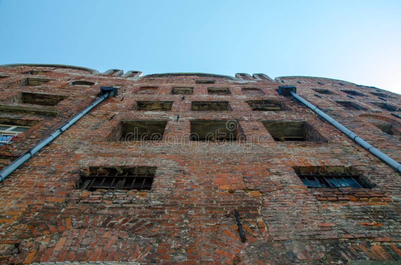 Vista di angolo basso della casa con mattoni a vista abbandonata con Windows rotto con immagini stock libere da diritti Vista di angolo basso della casa con mattoni a vista abbandonata con Windows rotto con immagini stock libere da diritti