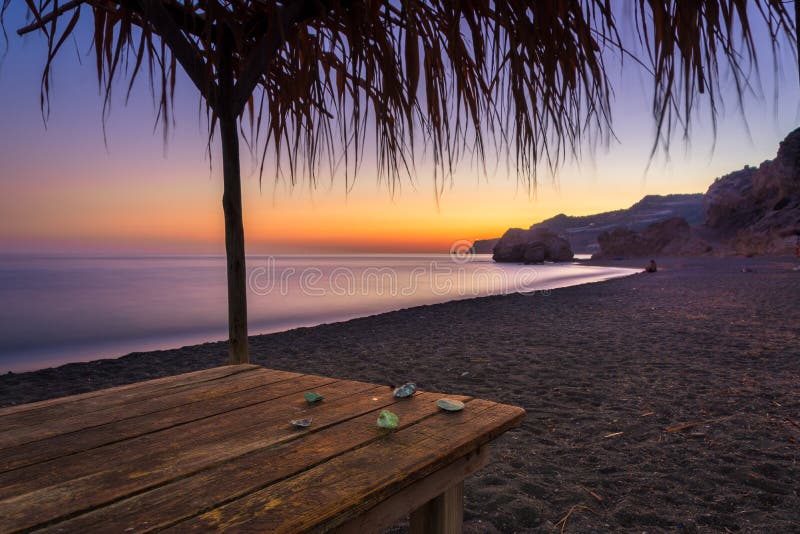 Vista di estate di una spiaggia al tramonto con le pietre su una tavola, Tertsa, Creta fotografie stock Vista di estate di una spiaggia al tramonto con le pietre su una tavola, Tertsa, Creta fotografie stock